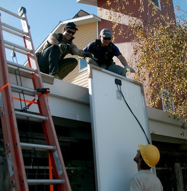 Donated solar panels are lifted to the roof of the nonprofit organization Committee on the Shelterless (COTS) in Sonoma County, California. © Everybody Solar.