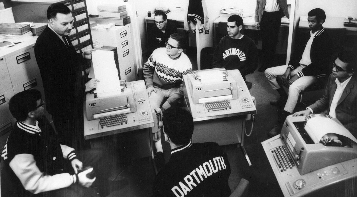 BASIC-Miterfinder John G. Kemeny mit einigen Studenten an mit dem DTSS verbundenen Fernschreibern – Bild mit freundlicher Genehmigung der Dartmouth College Library