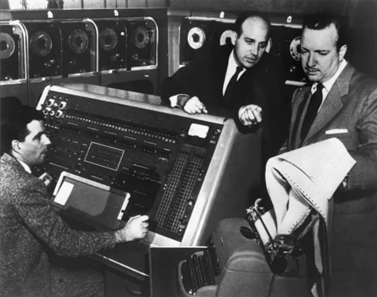Die UNIVAC I, vorne die Bedienkonsole, im Hintergrund Bandlaufwerke – Bild: United States Census Bureau (Public Domain)