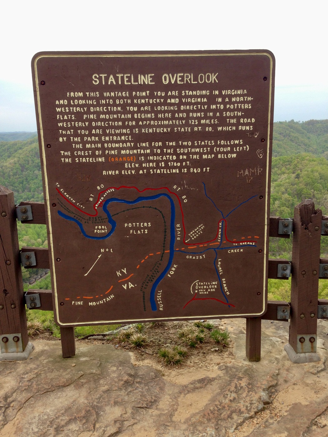 Waypoint sign with state line, highway, river, and railroad shown