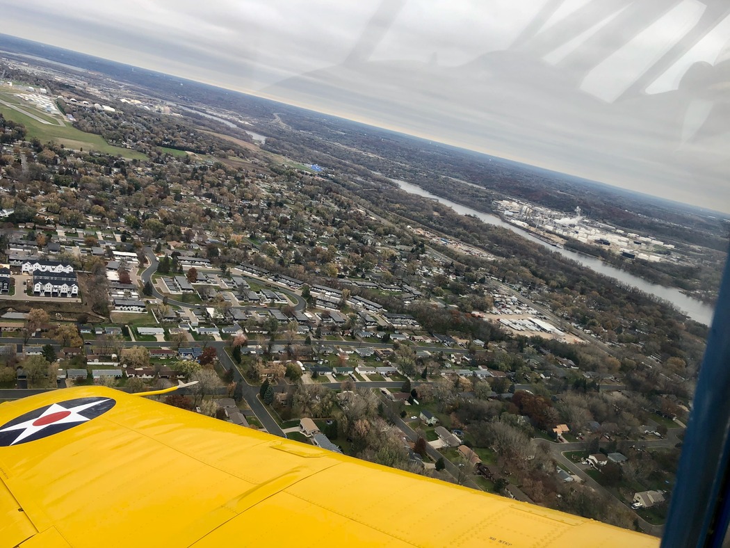 View from the back seat of a 1941 Vultee Valiant training aircraft, preparing to land at airport at top left of photo